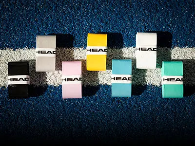 Ensemble de differents grip de raquette de Padel de la marque Head, disposés sur un terrain de Padel.